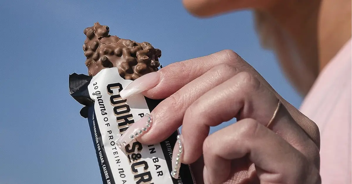 Girl Holding a Barebells Bar Cookies and Cream